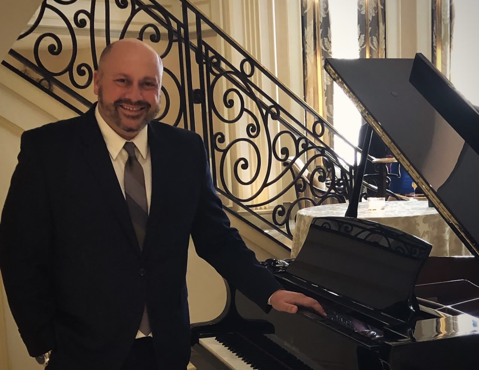 New Jersey pianist Vito Barbiera beside a black grand piano at an elegant event